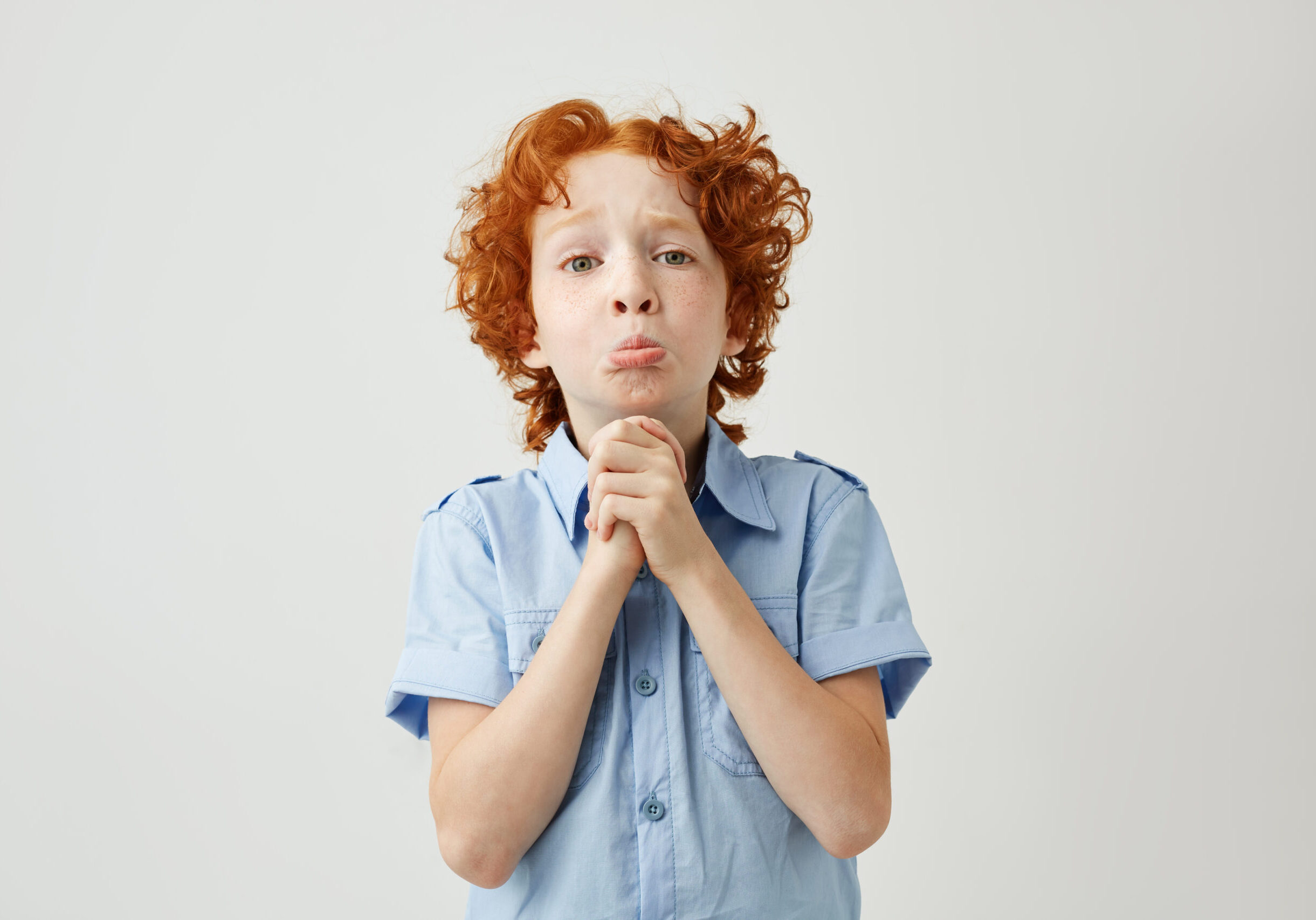 Funny ginger boy with sad and guilty face expression trying apologizes to his mom after lying her about being at school. Body language Funny ginger boy with sad and guilty face expression trying apologizes to his mom after lying her about being at school. Body language.